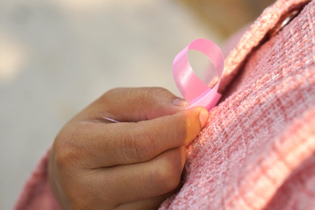 Lazo rosa en el pecho de una mujer Día Internacional de la Mujer