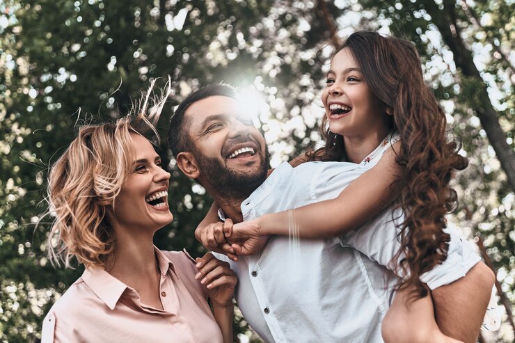 Foto lazos familiares. familia joven feliz de tres sonriendo mientras pasa tiempo libre al aire libre