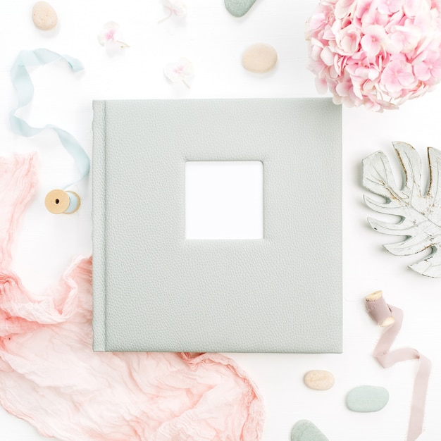 Álbum de fotos de família ou casamento com espaço em branco para texto, buquê de flores de hortênsia, cobertor rosa, decoração na superfície branca