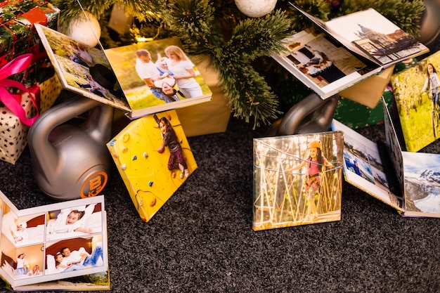 Álbum de fotos, álbum y pesas para deportes cerca del árbol de Navidad como regalo de vacaciones.