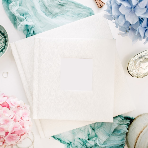 Álbum de fotos de boda familiar, ramo de flores de hortensias de colores pastel, manta turquesa, decoración en superficie blanca