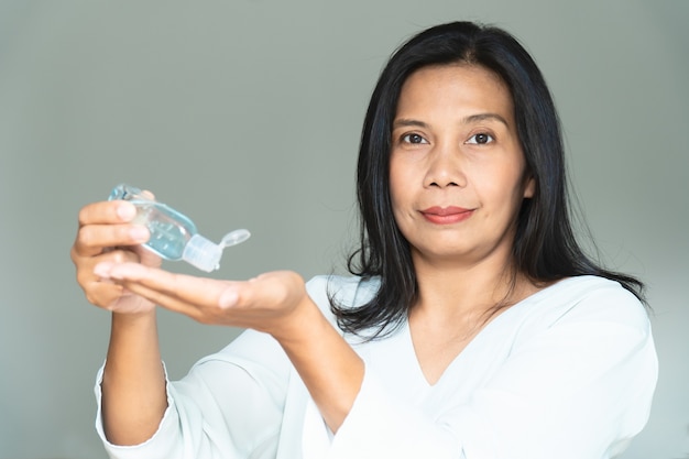 Álcool gel desinfetante para as mãos. Uso feminino para limpar as mãos e proteger contra o vírus Corona, COVID-19.