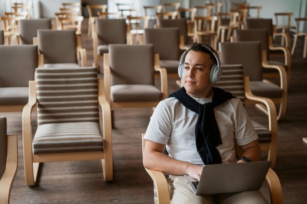 Lê informações e um ebook em um laptop Um homem em uma aula na universidade Estudante