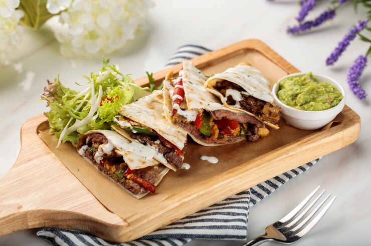 Foto le special shawarma wraps com salada e molho servido em uma tábua isolada na vista lateral da mesa de comida árabe