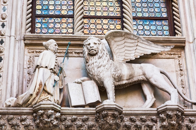 Leão alado e um padre, detalhe do palácio ducal palazzo ducale em veneza, itália,