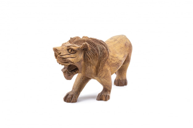 Foto leão esculpido em madeira isolada em uma parede branca.
