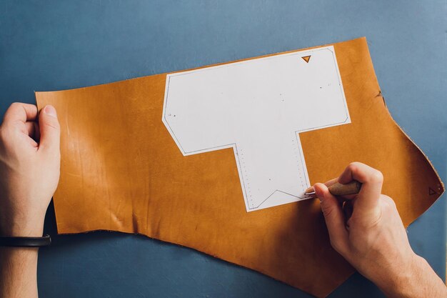 leather craftsman working making products at table in workshop studio