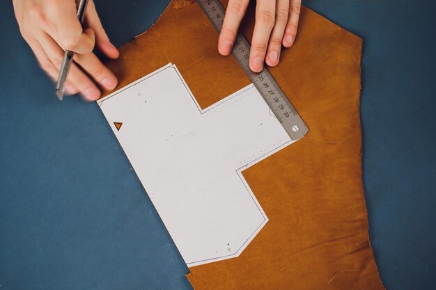 leather craftsman working making products at table in workshop studio
