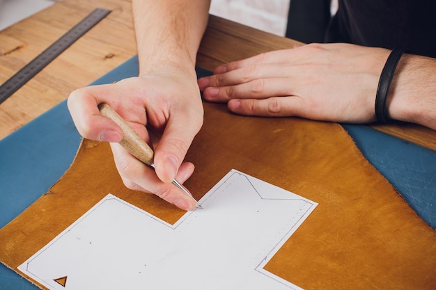 leather craftsman working making products at table in workshop studio