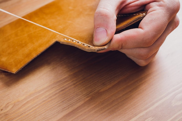 leather craftsman working making products at table in workshop studio