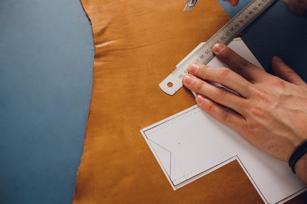 leather craftsman working making products at table in workshop studio