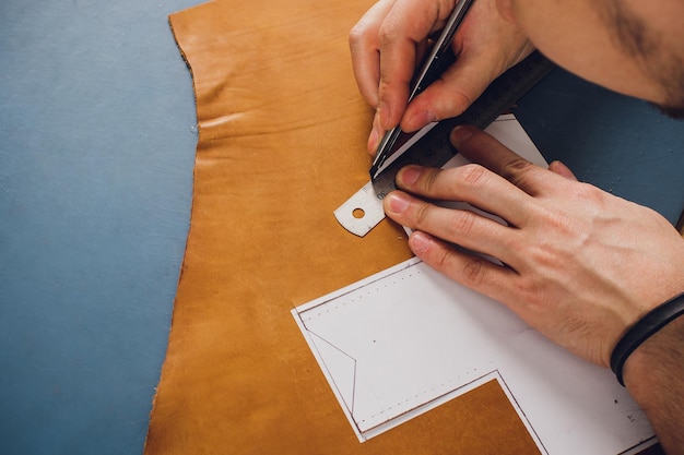 leather craftsman working making products at table in workshop studio