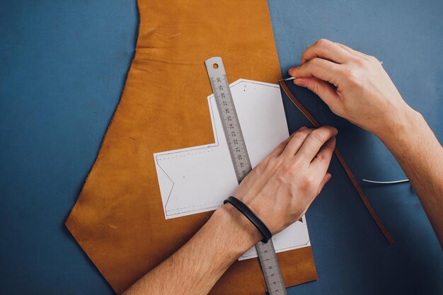 leather craftsman working making products at table in workshop studio