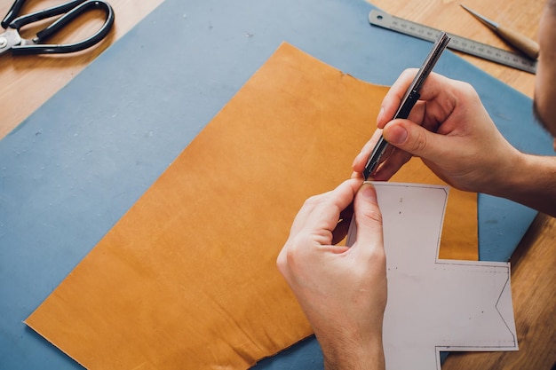 leather craftsman working making products at table in workshop studio
