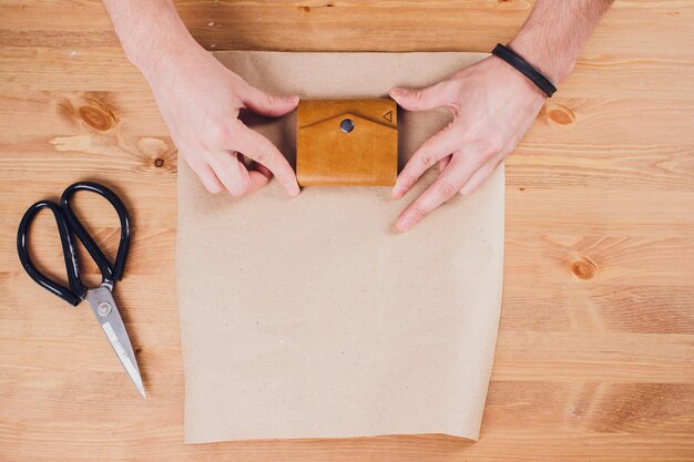 leather craftsman working making products at table in workshop studio