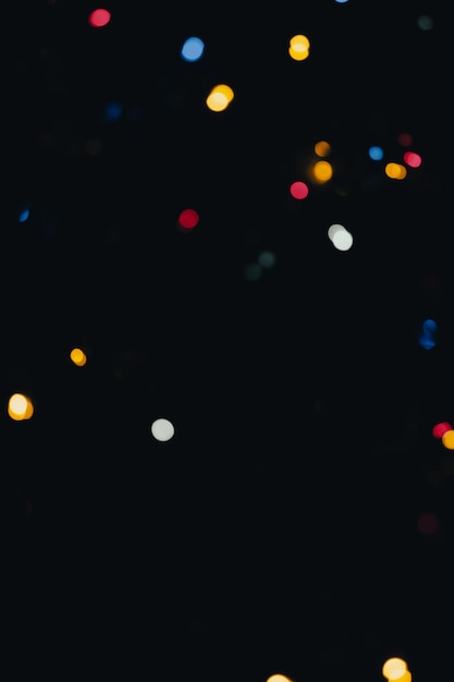 lebendige Anzeige mehrfarbiger Bokeh-Lichter vor einem dunklen Hintergrund, die eine festliche und magische Atmosphäre schaffen