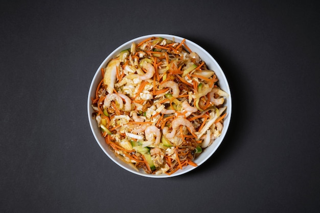 Lebendiger Teller mit Garnelensalat. Traditioneller Garnelensalat mit Gemüse