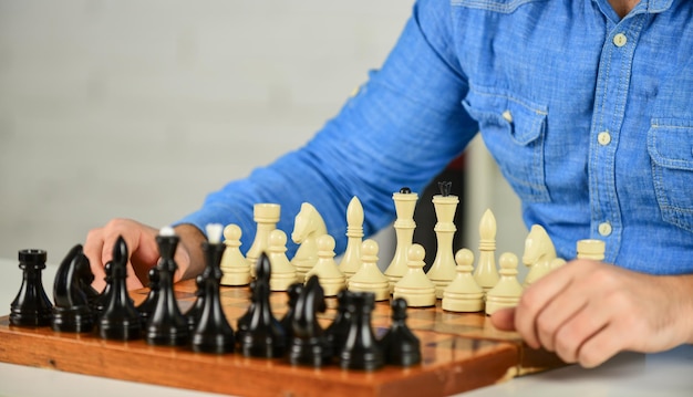 Lebenskompetenzen durch Schach Schachbrett mit Schachfiguren Turnierstrategie Schultafel Spaß Lehrer machen Trainingsstunde Bildungskonzept Mann spielt intellektuelles Spiel Kluger Mann spielt Schach