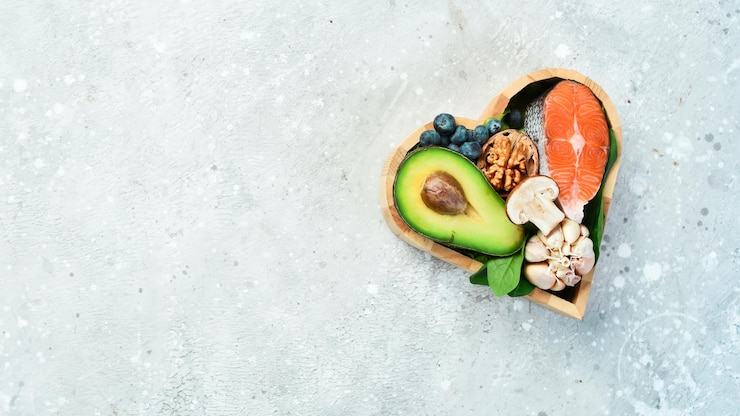 Foto lebensmittel, die gut für das herz sind nüsse lachs avocados spinat pilze beeren in einer herzförmigen box auf einem steinhintergrund ansicht von oben kopieren sie platz