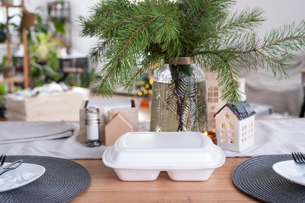 Lebensmittel-Lieferservice-Container auf dem Tisch in der weißen Küche, die festlich zur Feier von Weihnachten und Neujahr serviert werden