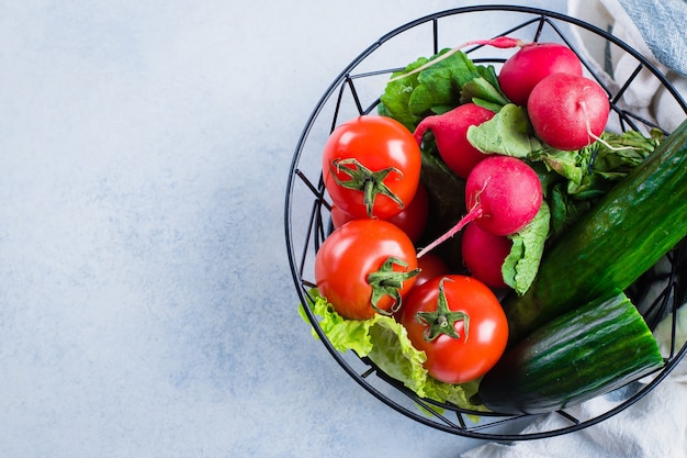 Lebensmittel Vegetarischer Hintergrund. Tomaten, Gurken, Radieschen, Salatblätter. Draufsicht, Raum kopieren