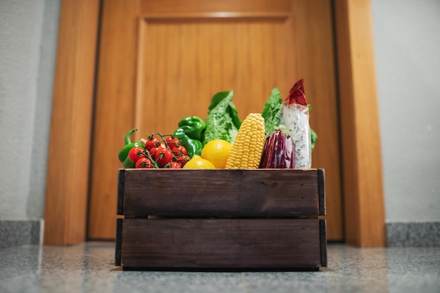 Lebensmitteleinkaufskiste steht an der Tür des Hauses oder der Wohnung Gemüse- und Obstlieferung während Quarantäne und Selbstisolation