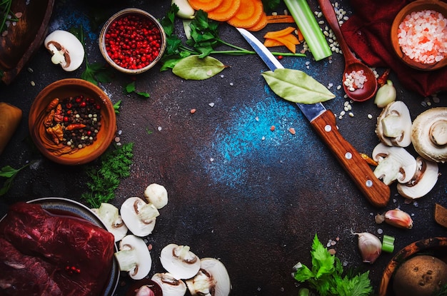 Lebensmittelkochhintergrund Frische Bio-Gemüsezutaten Gewürze und Fleisch für warme Herbstsuppe...