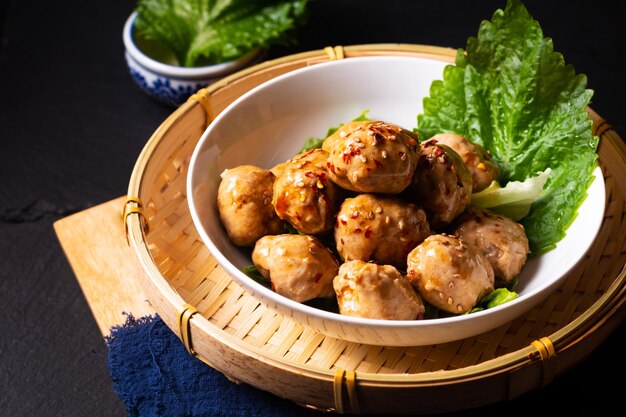 Lebensmittelkonzept hausgemachte asiatische Fleischbällchen mit süßer und würziger Sojasauce auf Holzbrett mit Kopierraum