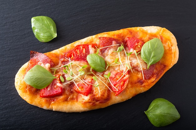 Lebensmittelkonzept Selbst gemachte organische Pizza mit Tomate, Basilikum und Schinken mit Kopienraum