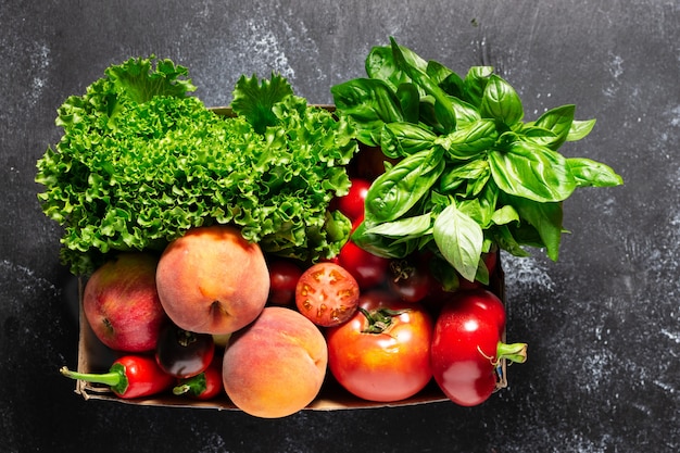 Lebensmittellieferkonzept für frische Landwirte. Bio-Gemüse, Obst und Gemüse in der Box auf schwarzem Tisch