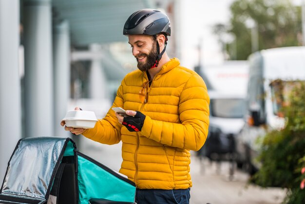 Lebensmittellieferservice, Fahrer, der Lebensmittel mit dem Fahrrad an Kunden liefert - Konzepte zu Transport, Lebensmittellieferung und Technologie