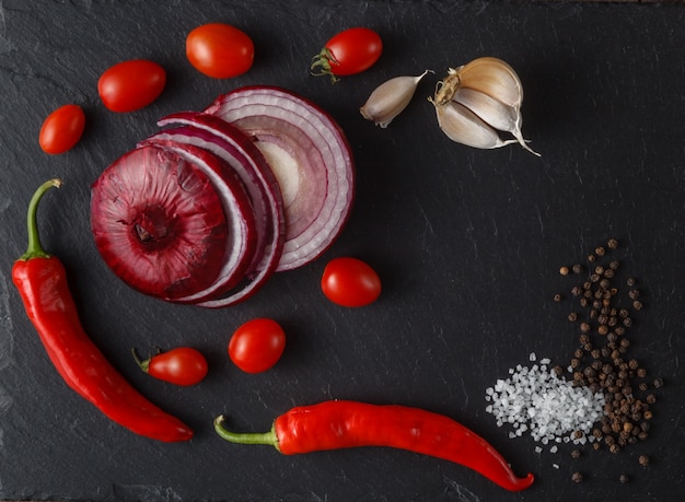 Lebensmittelzutaten: Tomaten, Salz auf schwarzem Schieferstein