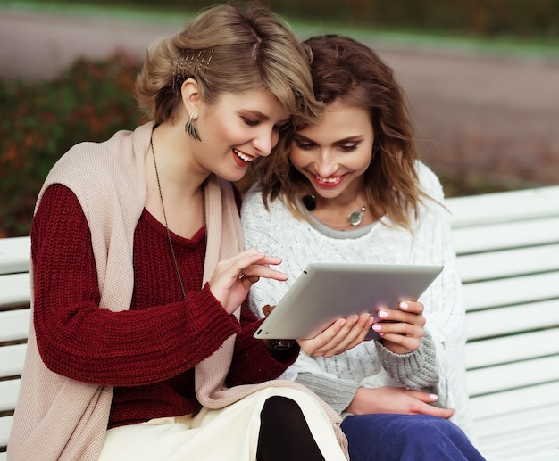 Lebensstil, Glück, Emotion und Menschenkonzept: schöne Frauen Mädchen Herbst mit Tablet im Freien