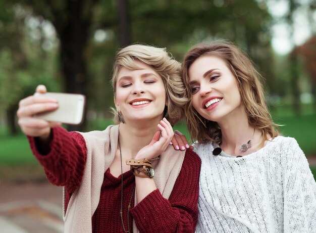 Lebensstil Glück emotional und Menschen Konzept Freunde machen selfie Zwei schöne junge Frauen machen selfie im Herbst Park