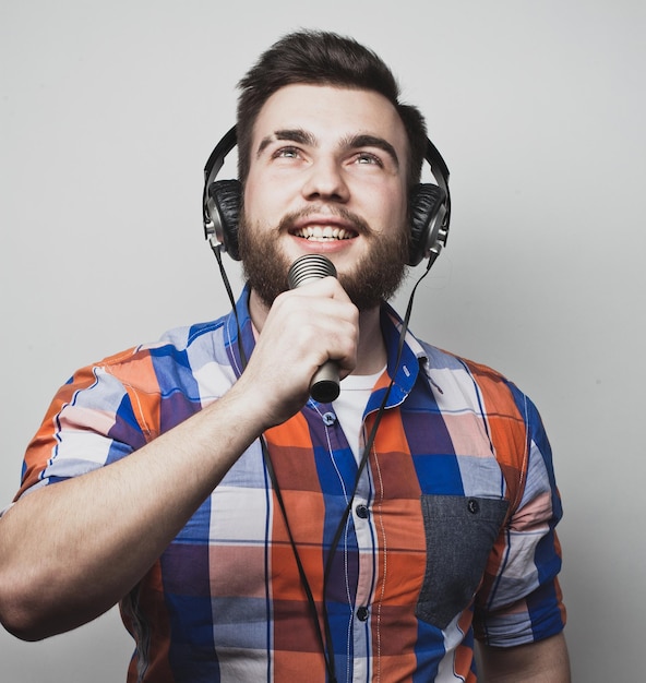 Lebensstil und Leutekonzept Junger Mann, der mit Mikrofon singt