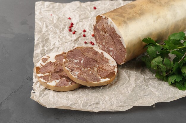 Leberwurst auf Pergament mit Petersilie auf grauer Nahaufnahme