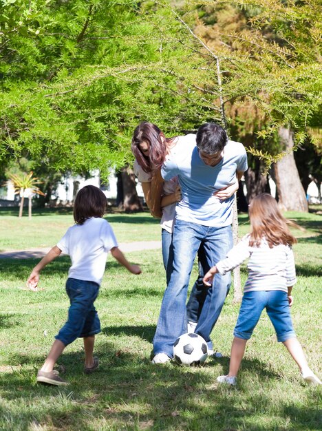 Lebhafte Familie, die Fußball spielt