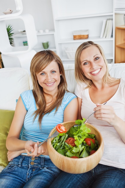 Lebhafte Frauen, die einen Salat essen