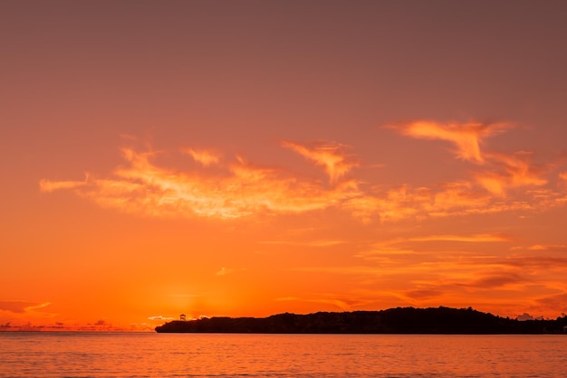 Lebhafter Sonnenuntergang in warmen Farben am Meereshimmel voller erstaunlicher Wolkenberge in der Silhouette