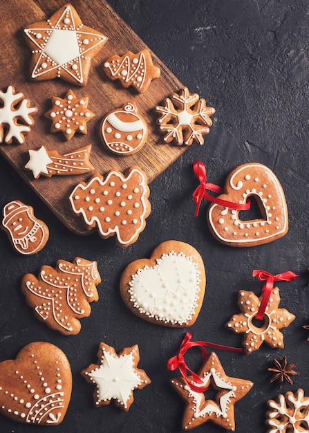 Lebkuchen Weihnachten und frohes neues Jahr Kekse Hintergrund auf schwarzer Textur, Kopie Raum, vertikal