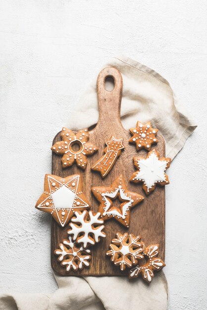 Lebkuchen Weihnachten und glückliche neue Jahre Kekse auf Holzschnittbrett auf weißem Hintergrund, Kopienraum, vertikal