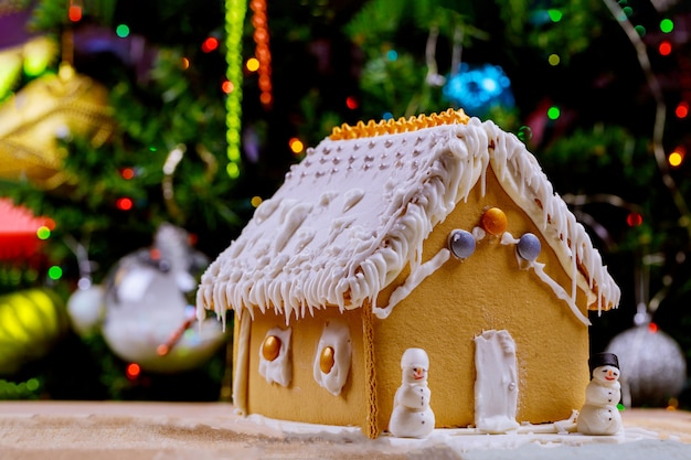 Lebkuchenhaus auf Lichtern von Chrismtas geschmücktem Baum