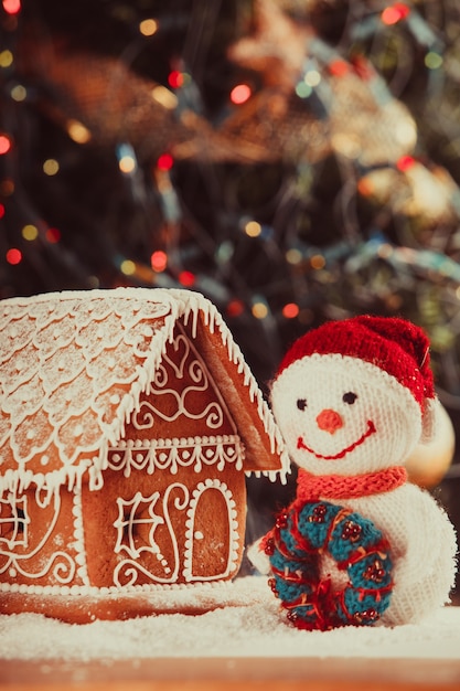 Lebkuchenhaus auf Schnee, Schneemann und Leuchter