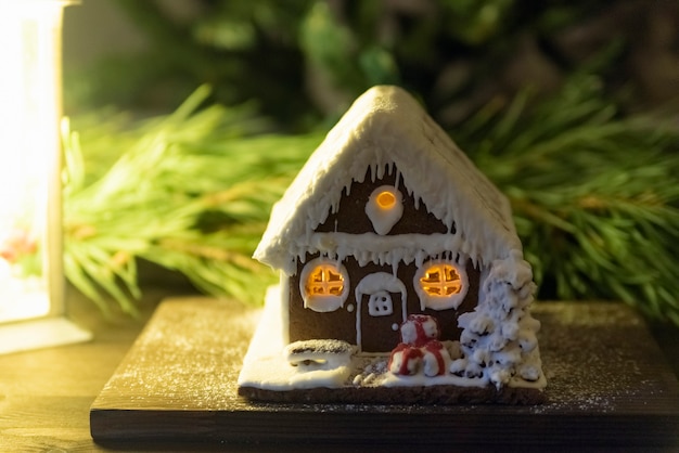 Lebkuchenhaus und Fichtenzweig im Hintergrund. Winterurlaub-Tradition.