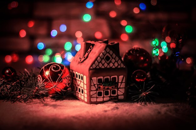 Lebkuchenhaus und Weihnachtsdekoration auf festlichem Hintergrund