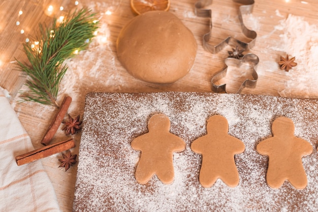 Lebkuchenmannplätzchen für Weihnachtsfeiertag. Herstellungsprozess. Nahaufnahme, Platz für Text