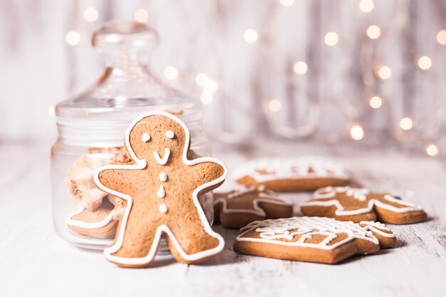 Lebkuchenplätzchen auf einem Tisch und Weihnachtsbeleuchtung im Hintergrund