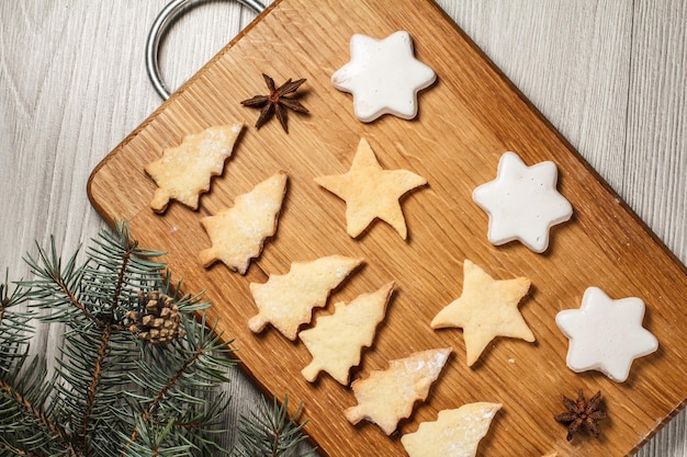Lebkuchenplätzchen in Weihnachtsbaum- und Sternform auf Holzbrett