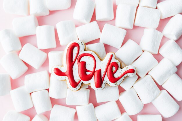 Lebkuchenplätzchen lieben mit weißem Marshmallow. Valentinskarte. Rosa Hintergrund. Hochwertiges Foto