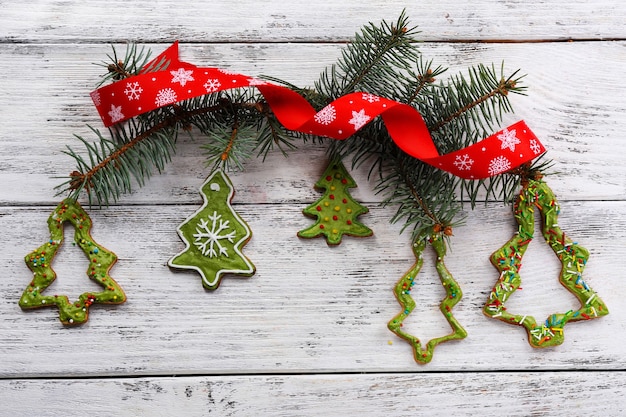 Lebkuchenplätzchen mit Weihnachtsdekoration auf farbigem Holztischhintergrund